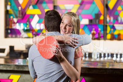 Couple embracing each other while holding gift