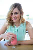 Portrait of smiling woman having a smoothie drink