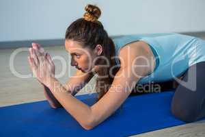 Woman performing yoga on exercise mat