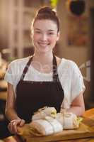 Portrait of smiling waitress holding a tray with sandwiches