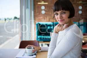 Smiling woman sitting in cafeteria