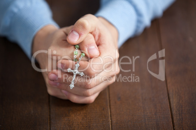 Praying hands of man with a rosary
