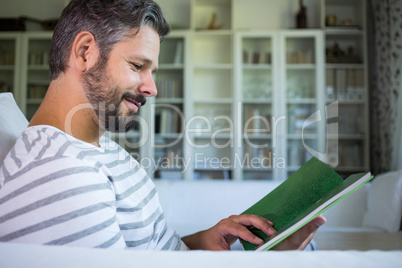 Father looking at photo album in living room