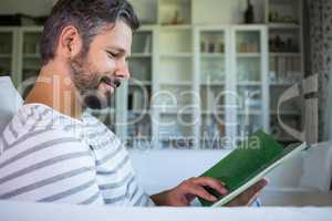 Father looking at photo album in living room