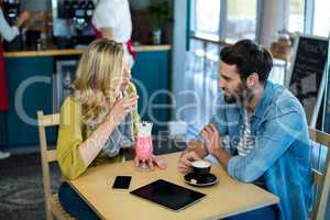 Couple interacting while having a cup of coffee and milkshake