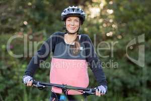 Female biker with mountain bike in countryside