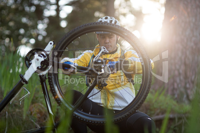 Male biker repairing mountain bike