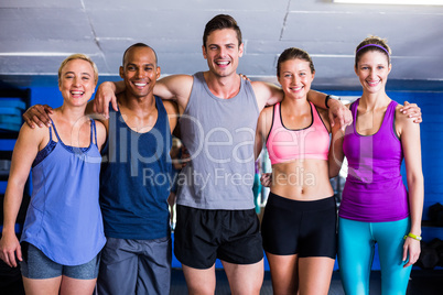 Portrait of smiling friends with arm around in gym