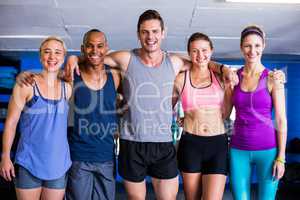 Portrait of smiling friends with arm around in gym