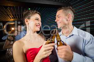 Happy couple toasting a beer bottles