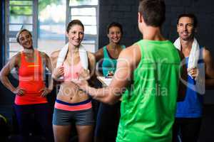 Fitness instructor discussing with happy people