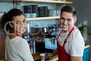 Smiling waitress and waiter in cafe