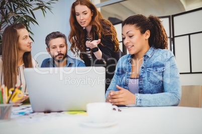 Creative businesswoman discussing with coworkers