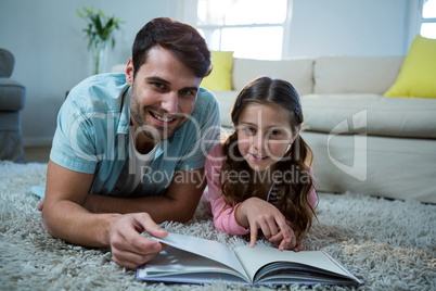 Father and daughter reading book in the living room