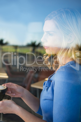 Thoughtful woman holding a coffee cup