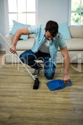 Man cleaning the floor with broom and dust picker