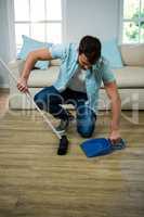Man cleaning the floor with broom and dust picker