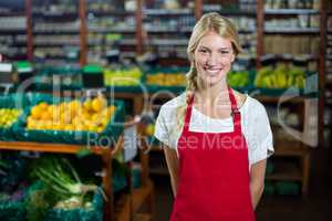 Smiling female staff standing in organic section