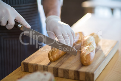 Waiter chopping bread roll on chopping board in cafÃ?Â©