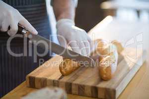 Waiter chopping bread roll on chopping board in cafÃ?Â©