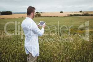 Agronomist using digital tablet in the field