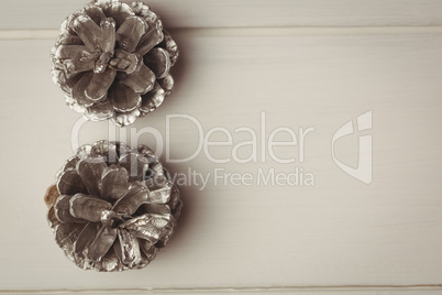 Two pine cones on wooden table