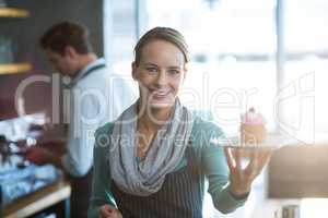 Portrait of waitress holding a plate of cupcake