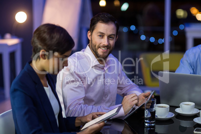 Businessman and businesswoman using digital tablet in office