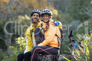 Biker couple sitting on a tree stump