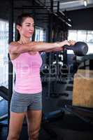 Young woman holding kettlebell in gym