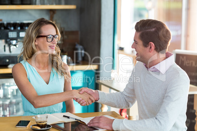 Friends shaking hands in cafÃ?Â©