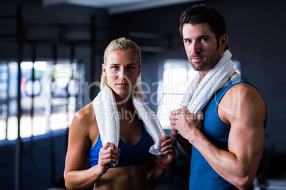 Portrait of serious friends with towel in gym