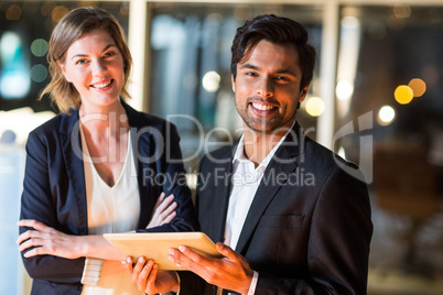 Businessman discussing with colleague over digital tablet