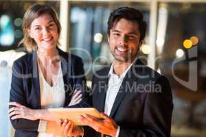 Businessman discussing with colleague over digital tablet