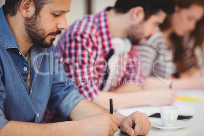 Businessman with coworkers writing on documents