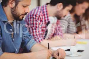 Businessman with coworkers writing on documents
