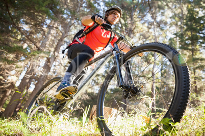 Male mountain biker riding bicycle in the forest