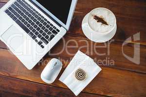 Coffee cup and laptop on a table