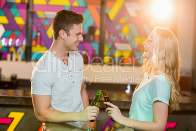 Happy couple toasting a beer bottles