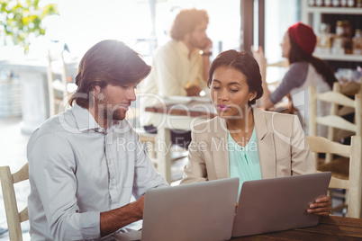 Man and woman using laptop during meeting