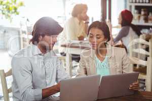 Man and woman using laptop during meeting