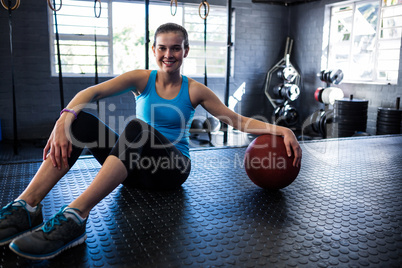 Smiling female athlete with exercise ball