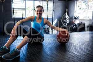 Smiling female athlete with exercise ball