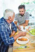 Father and son talking to each other while having breakfast