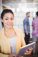 Portrait of happy businesswoman using digital tablet at creative office