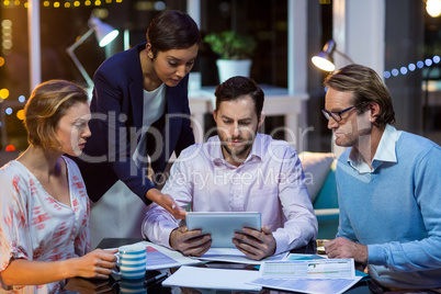 Businesspeople discussing on digital tablet in office