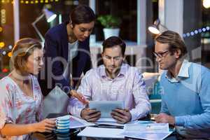 Businesspeople discussing on digital tablet in office