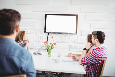 Executives watching at television in creative office