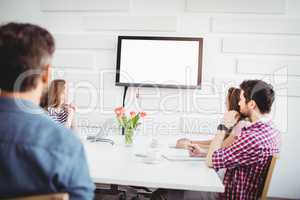 Executives watching at television in creative office