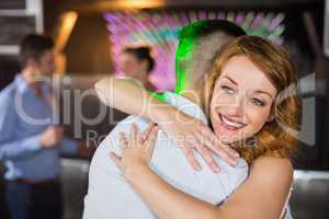 Smiling couple embracing each other in bar